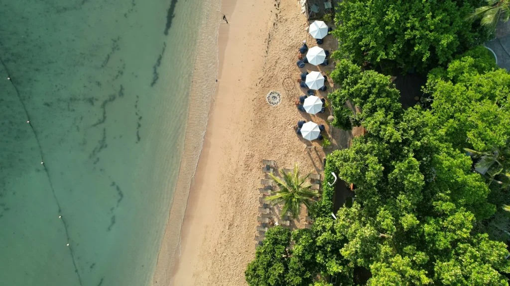 Homokos strand napernyőkkel és pálmákkal felülről, Bali