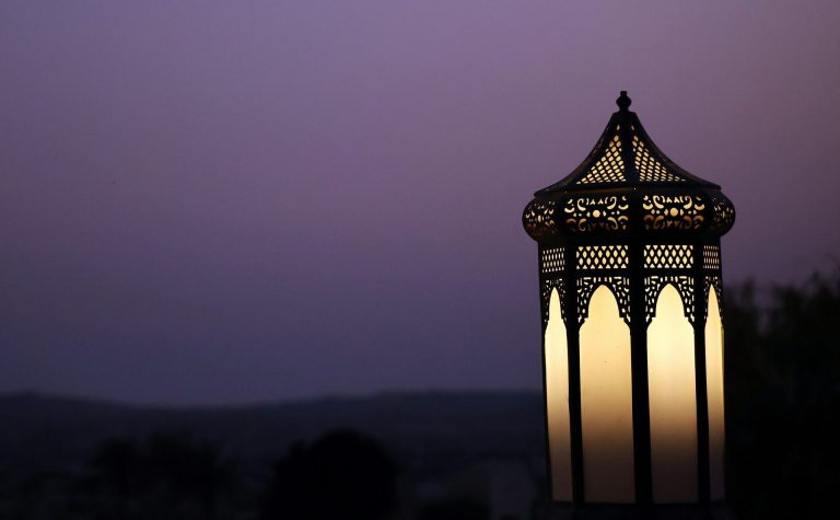Világító, áttört mintás arab lámpás alkonyatkor Abu Dhabiban, lila égbolt előtt