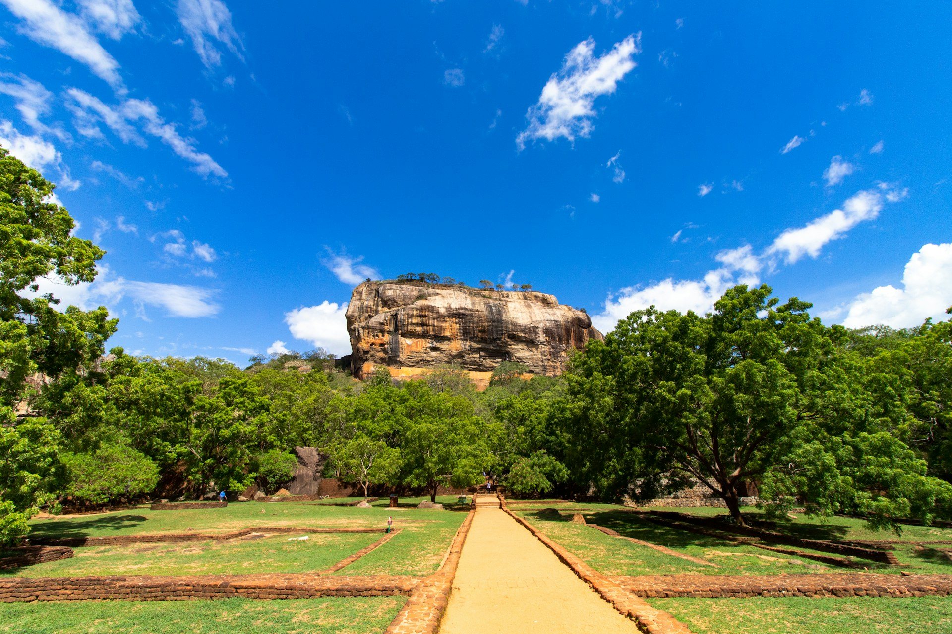 Ösvény vezet a Sigiriya sziklaerőd felé kék ég alatt, Srí Lanka