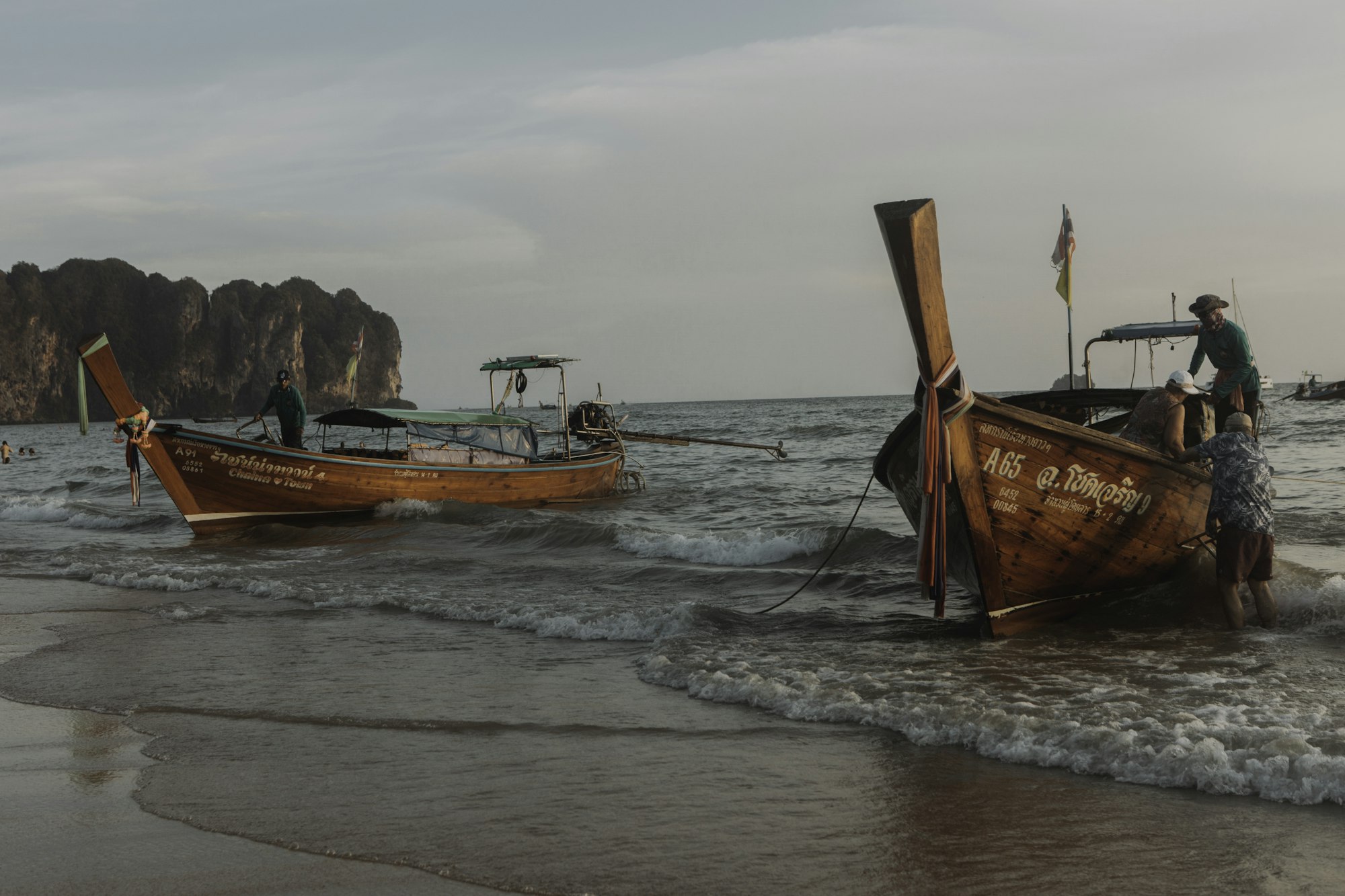 Thai longtail hajók a krabi parton, háttérben mészkősziklákkal